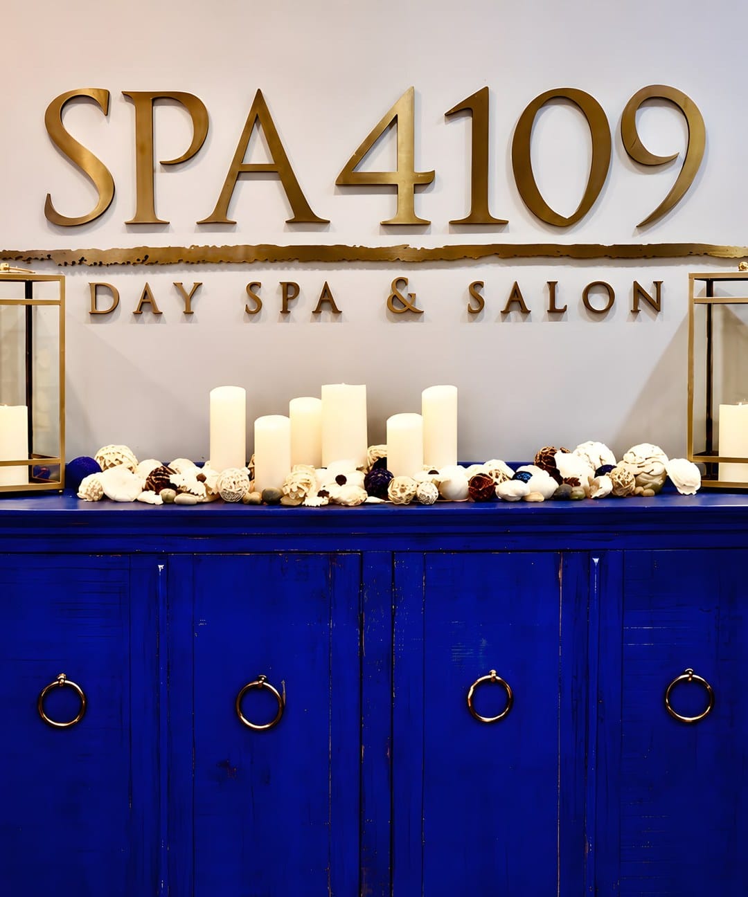 Spa 4109 — Day Spa & Salon: the gold SPA 4109 signage above a cobalt-blue console with candles, gold lanterns, and dried florals in Lynchburg, VA